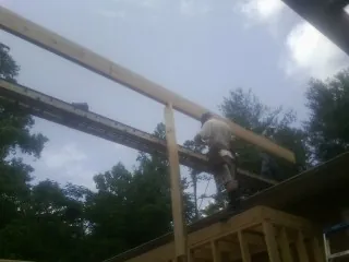 Carpenter setting a ridge beam over a new addition frame — Ice Dam Removal by Roofing Brothers in Fort Scott