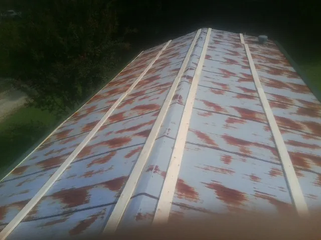 Rusted metal roof panels with new wood purlins before replacement — Storm Damage Roof Repair in Fort Scott by Roofing Brothers