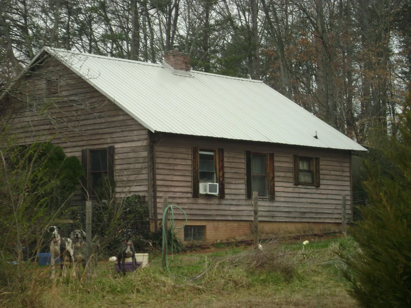White metal roof on an old wood sided farmhouse, from a Metal Roof Installation job in Fort Scott
